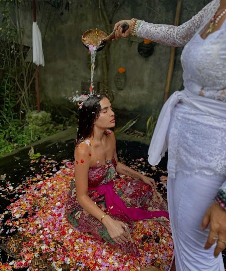 Mulher recebendo o ritual balinês de purificação com água e flores